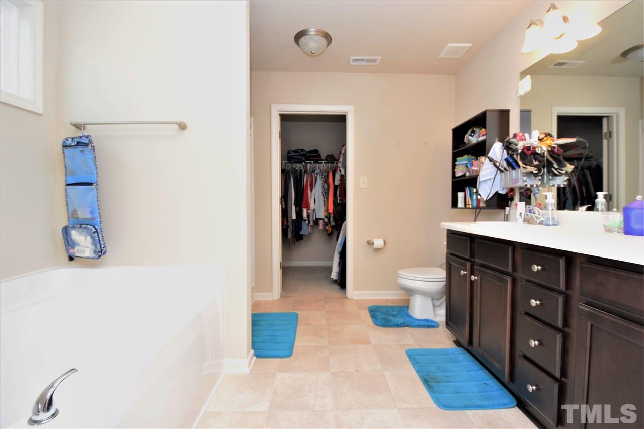 582 Roberts Road Willow Spring, NC 27592 - Photo 12 of 17 a spacious bathroom with a double vanity sink a large mirror and a toilet