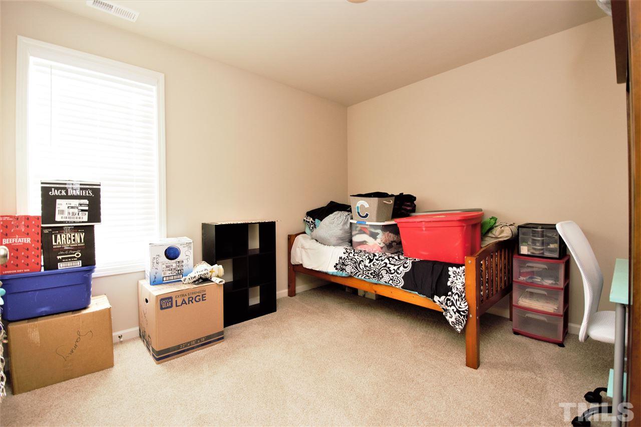 582 Roberts Road Willow Spring, NC 27592 - Photo 15 of 17 a bedroom with furniture and a fireplace