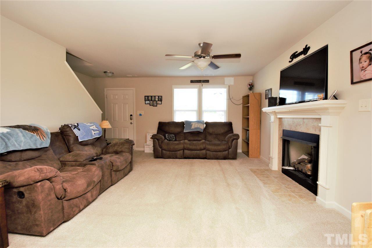 582 Roberts Road Willow Spring, NC 27592 - Photo 5 of 17 a living room with furniture a fireplace and a flat screen tv