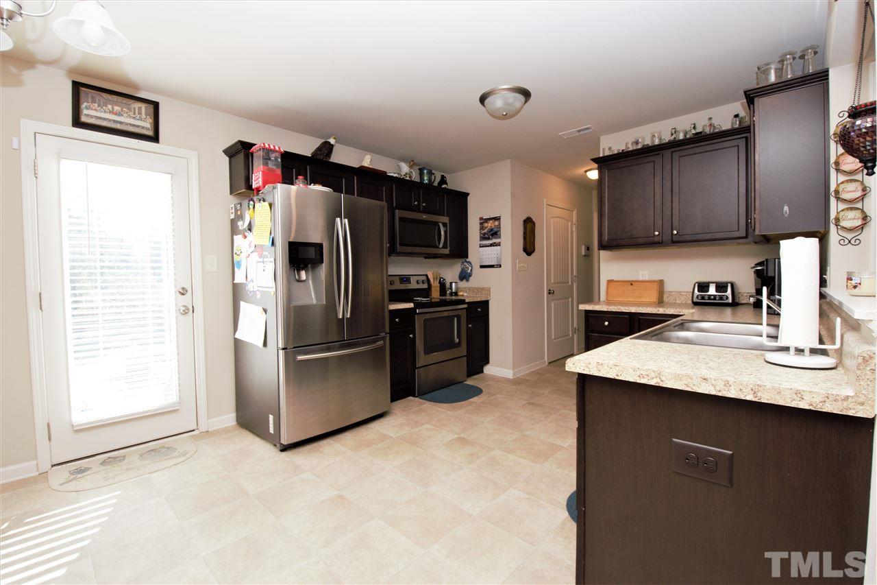 582 Roberts Road Willow Spring, NC 27592 - Photo 7 of 17 a kitchen with stainless steel appliances granite countertop a refrigerator a sink a stove a microwave and island