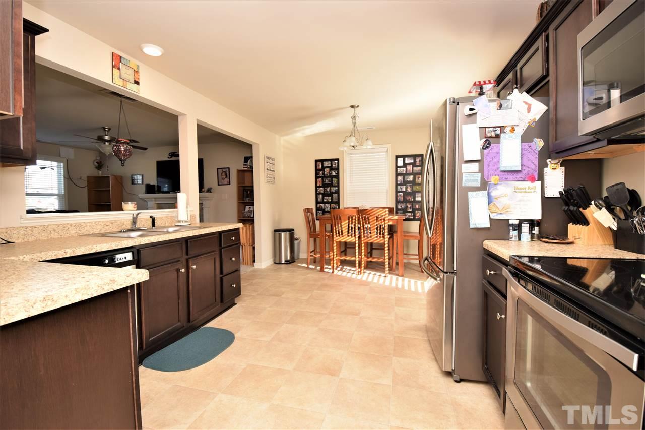 582 Roberts Road Willow Spring, NC 27592 - Photo 8 of 17 a large kitchen with stainless steel appliances a stove a sink dishwasher and cabinets with wooden floor