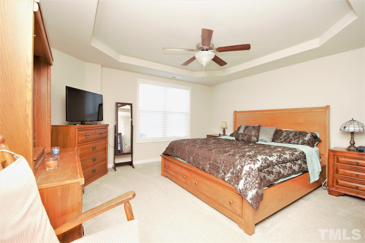 582 Roberts Road Willow Spring, NC 27592 - Photo 10 of 17 a bedroom with a bed flat screen tv and a couch