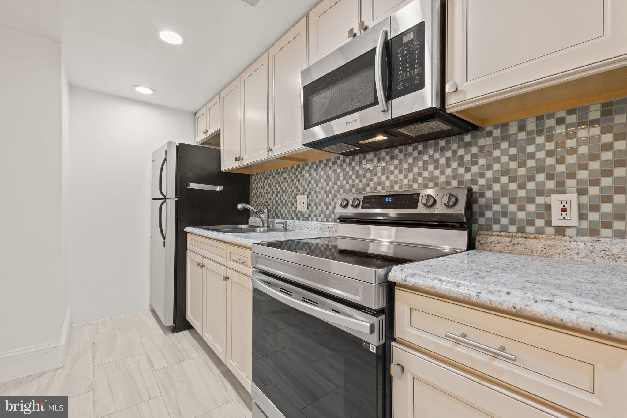 1308 Park Road Northwest, Unit 2 Washington, DC 20010 - Photo 6 of 17 a kitchen with stainless steel appliances granite countertop a sink stove and microwave