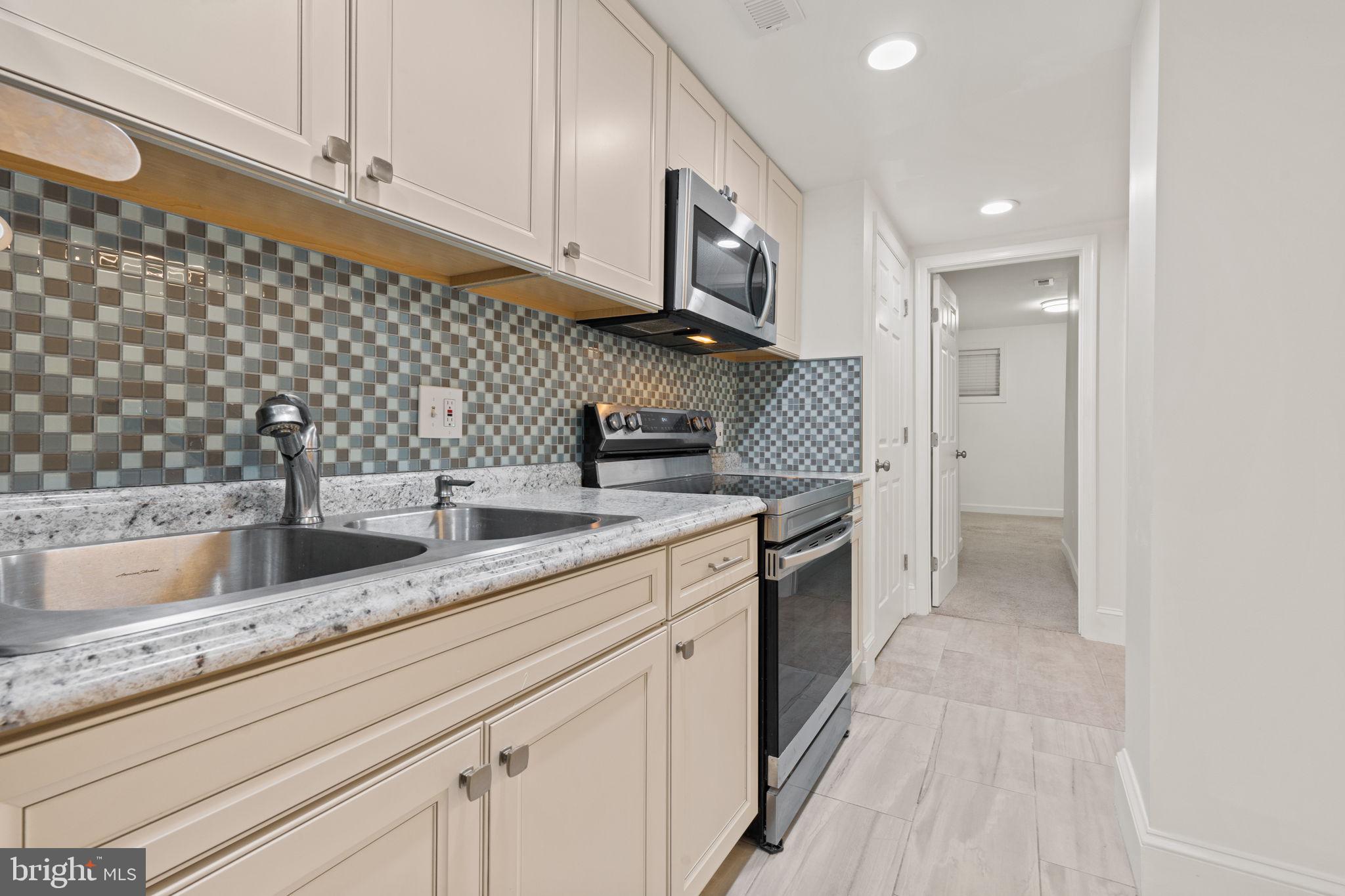 1308 Park Road Northwest, Unit 2 Washington, DC 20010 - Photo 7 of 17 a kitchen with granite countertop a sink stainless steel appliances and cabinets