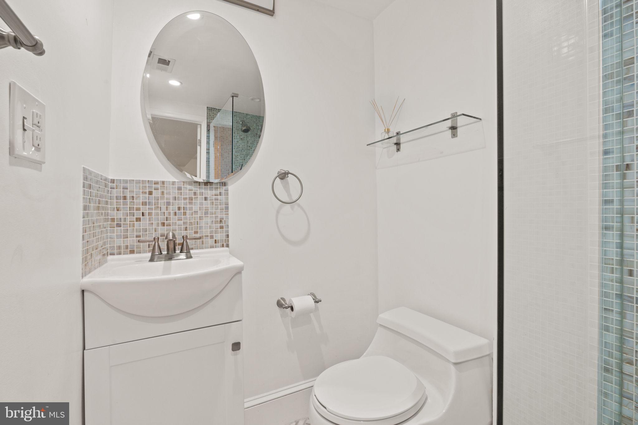 1308 Park Road Northwest, Unit 2 Washington, DC 20010 - Photo 10 of 17 a bathroom with a toilet sink mirror and vanity