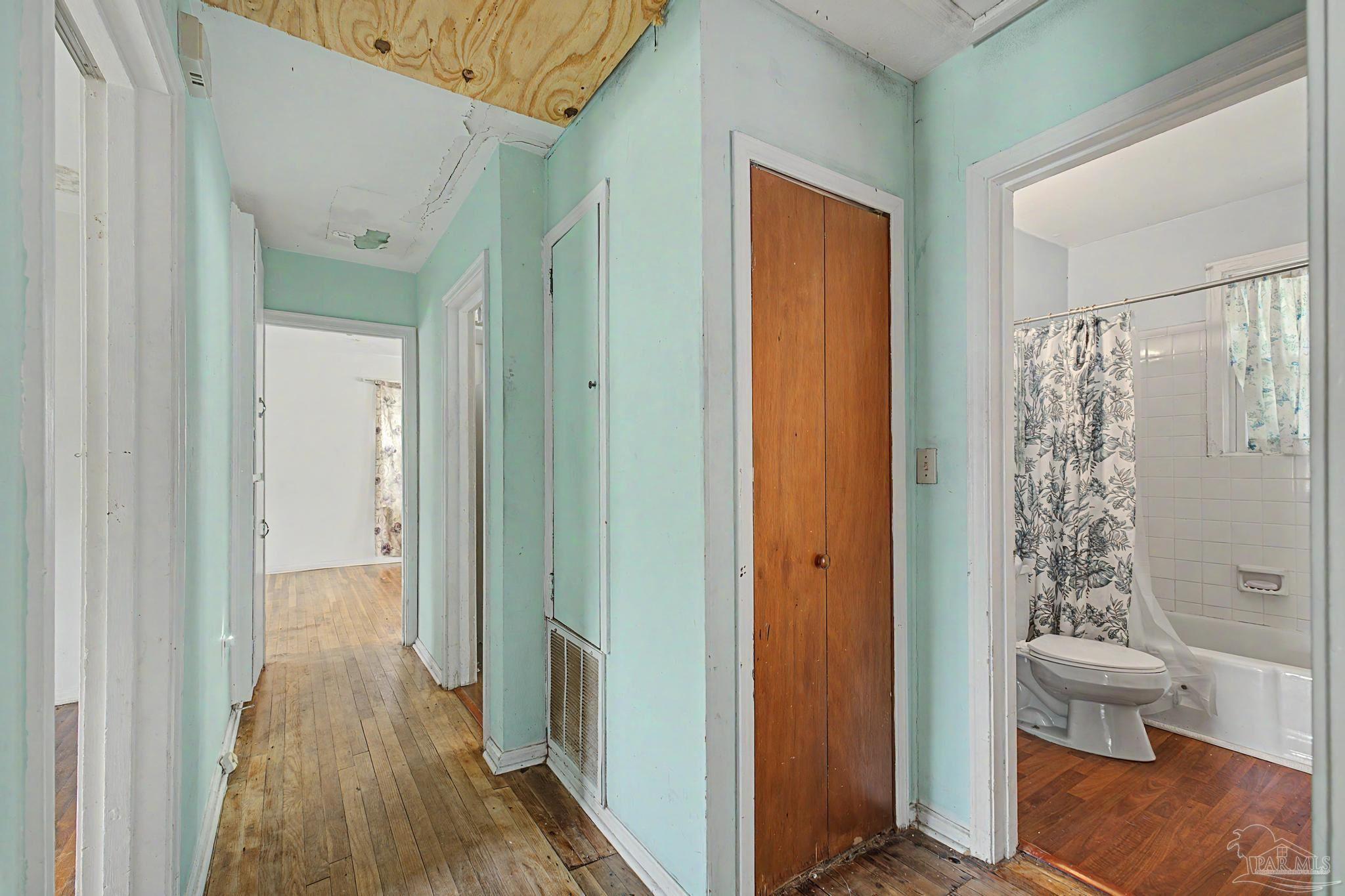 333 Gibbs Road Pensacola, FL 32507 - Photo 17 of 34 a view of a hallway with wooden floor and a bathroom