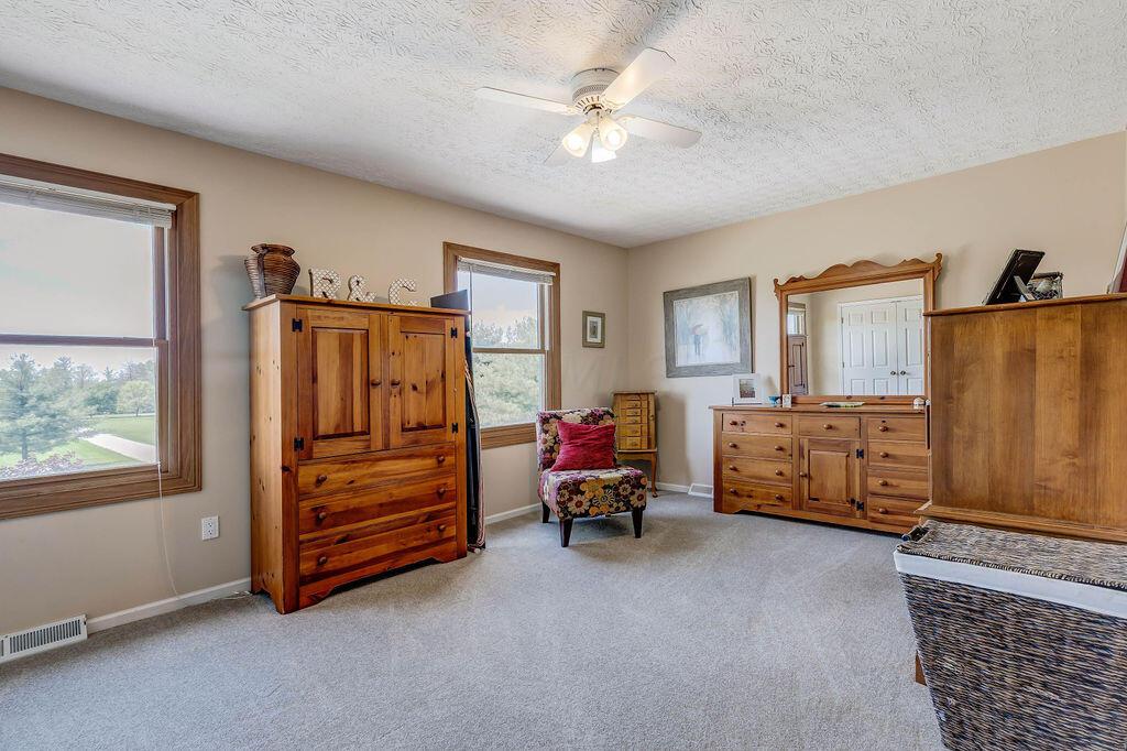 1300 Hubbard Road Galloway, OH 43119 - Photo 33 of 89 • Light sand carpet • Tan painted walls • Lighted ceiling fan • Closet with 2 doors • Mini blinds • Open vanity desk