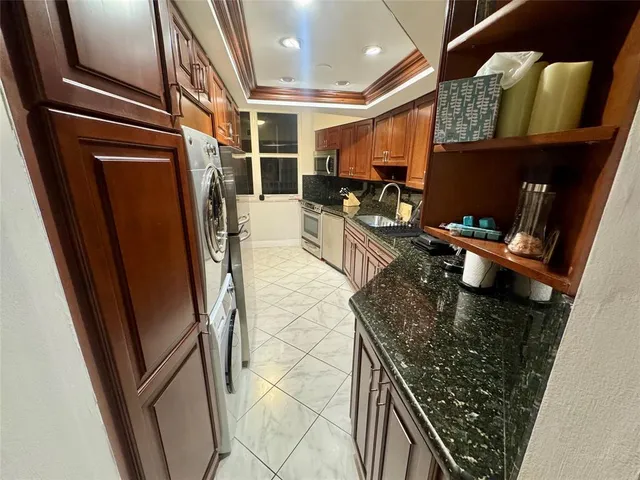 a kitchen with stainless steel appliances granite countertop a refrigerator and a counter space