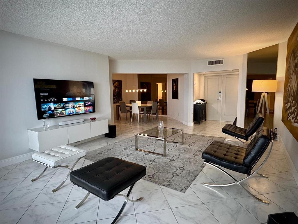 1340 South Ocean Boulevard, Unit 1109 Pompano Beach, FL 33062 - Photo 15 of 42 a living room with furniture and a flat screen tv