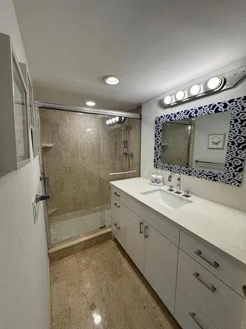 a bathroom with a double vanity sink mirror and shower