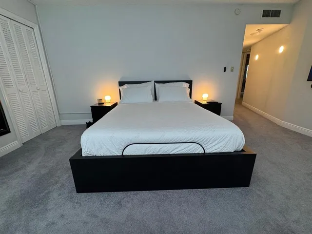 a bedroom with a bed and a night stand