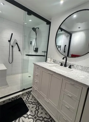 a bathroom with a granite countertop sink mirror and vanity