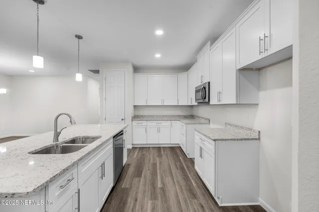 a view of kitchen with wooden floor and electronic appliances