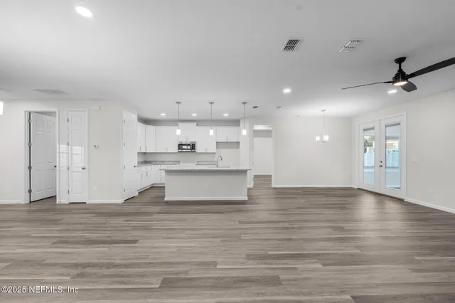 a large kitchen with stainless steel appliances kitchen island a hardwood floor and a sink