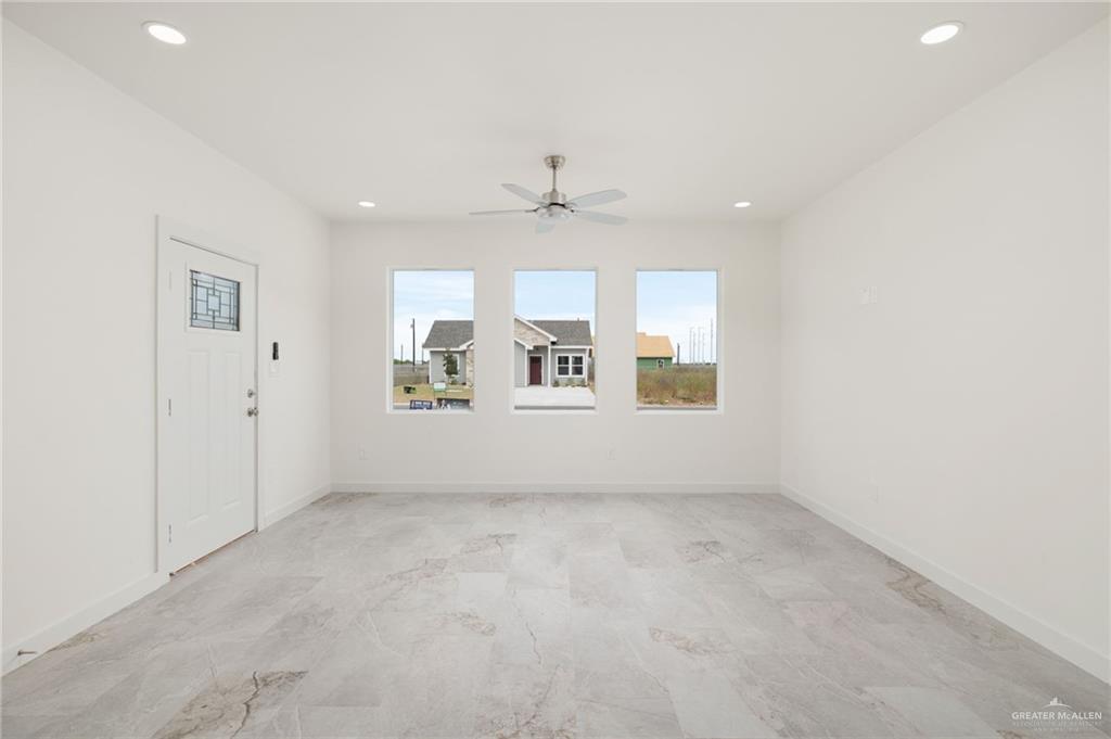 321 Merida Drive Donna, TX 78537 - Photo 2 of 11 an empty room with chandelier fan and windows