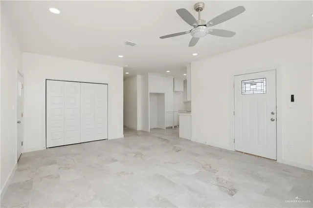 an empty room with fan and a ceiling fan