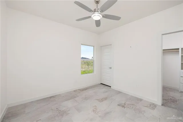 an empty room with a window and a fan