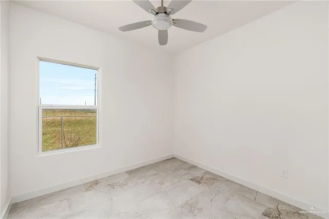 an empty room with a window and a fan