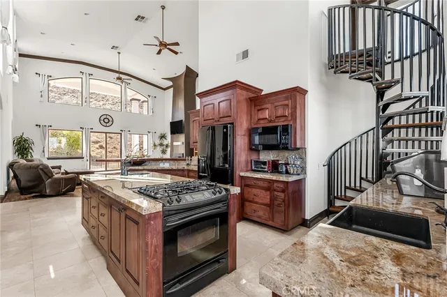 a kitchen with stainless steel appliances granite countertop a stove top oven a dining table and chairs with wooden floor