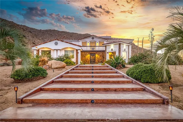 a view of a white house with a yard and plants