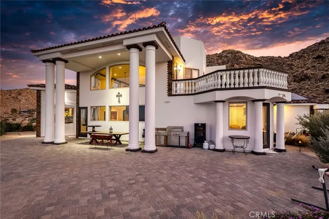 a view of a house with furniture and a car parked in front of it