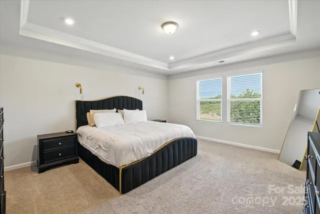 a bedroom with a bed lamp and a large window