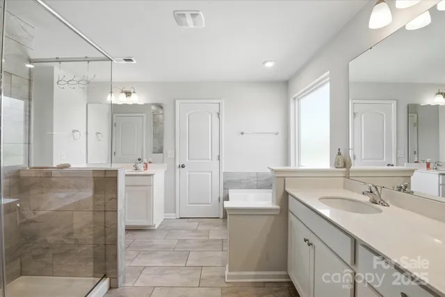 a spacious bathroom with a shower sink and mirror