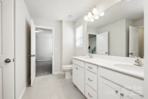 a spacious bathroom with a double vanity sink mirror and toilet