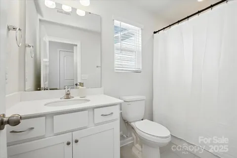 a bathroom with a toilet a sink and a window