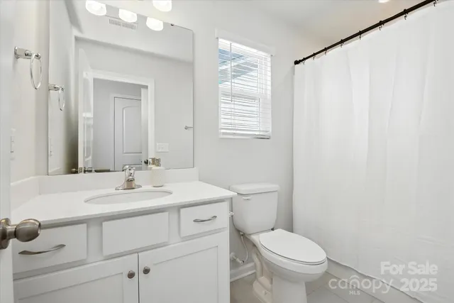 a bathroom with a toilet a sink and a window