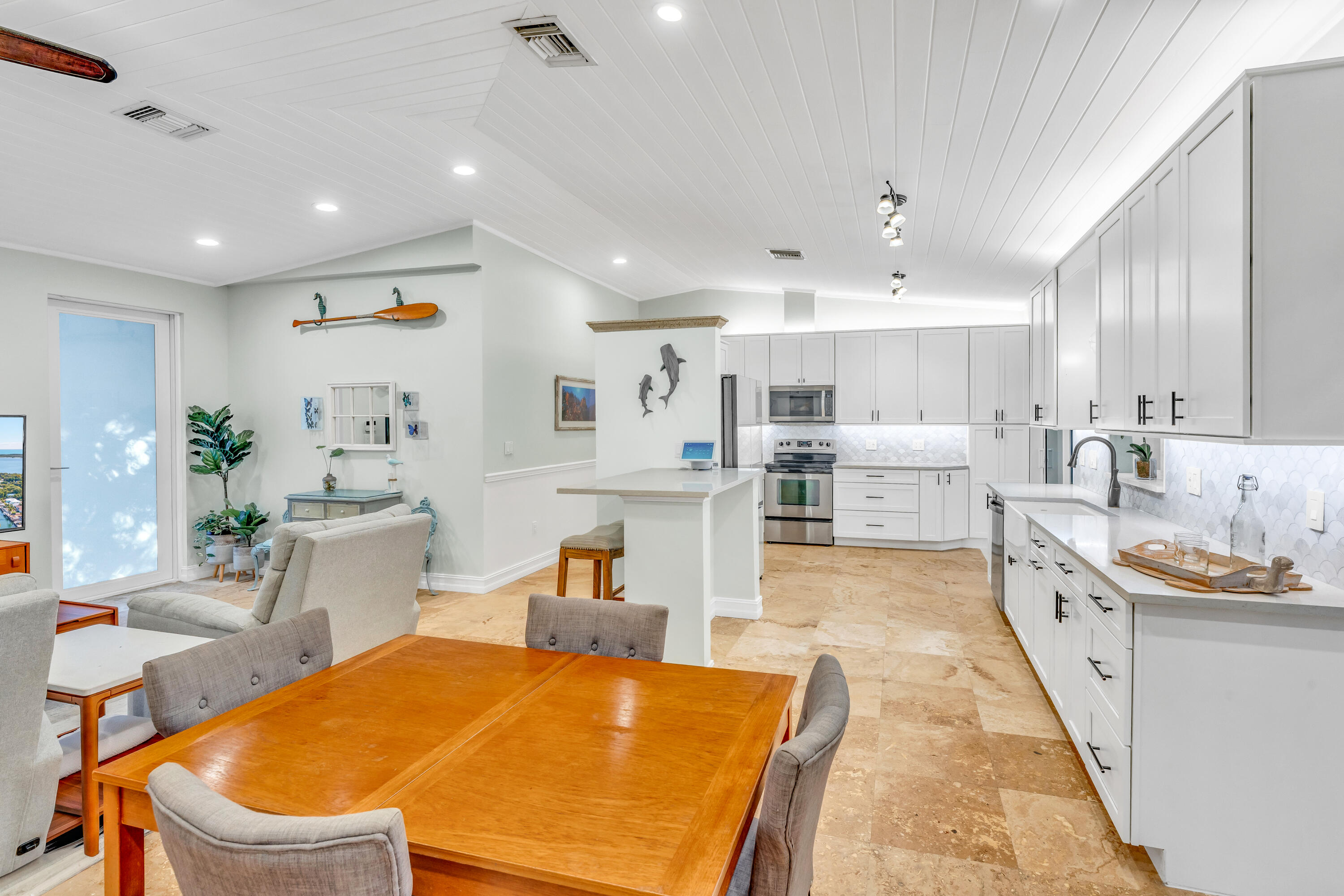 33 Blue Runner Street Key Largo, FL 33037 - Photo 15 of 60 a large kitchen with kitchen island a stove a sink a dining table and chairs