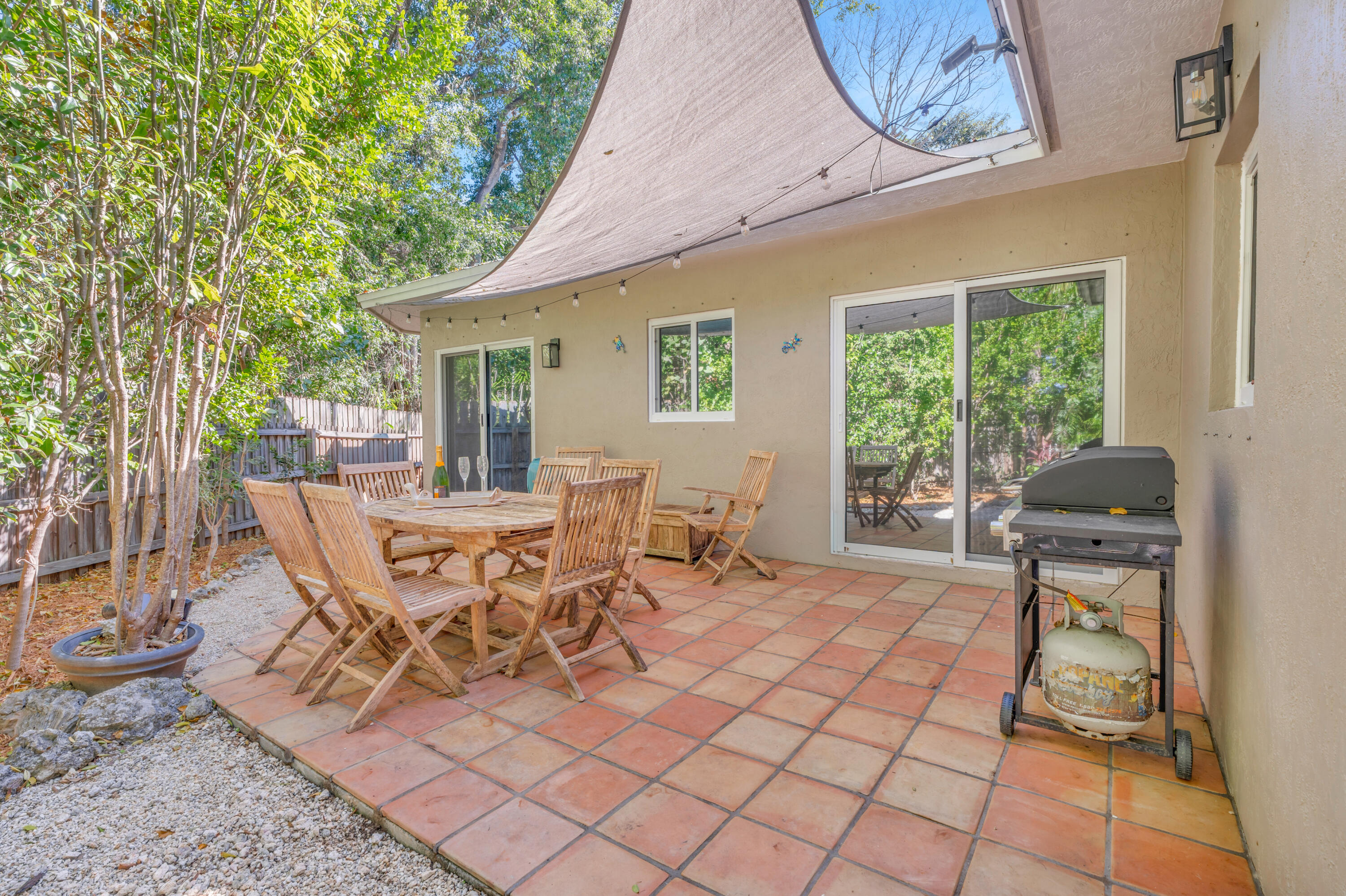 33 Blue Runner Street Key Largo, FL 33037 - Photo 40 of 60 a view of a patio with table and chairs near a garden