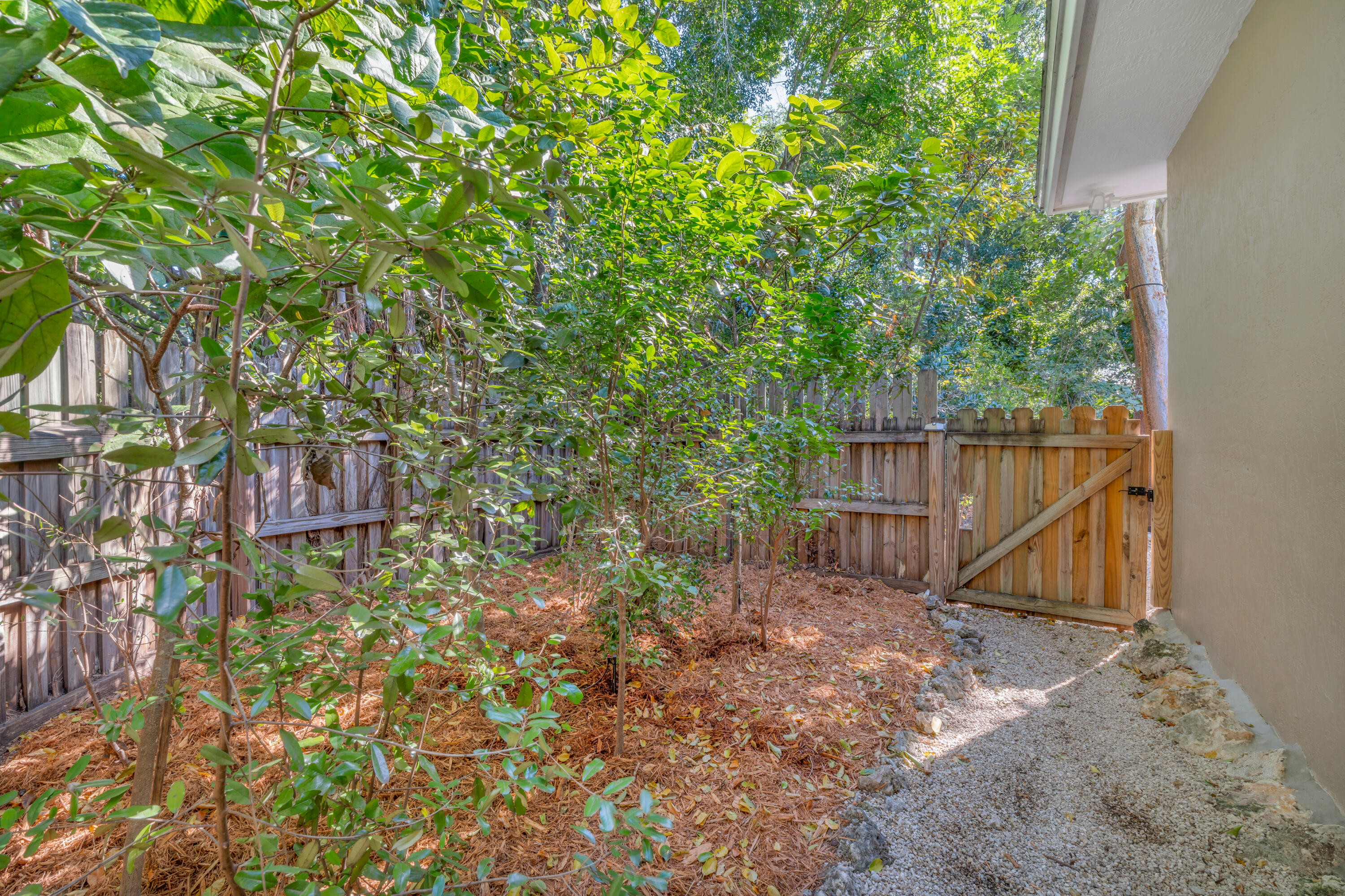 33 Blue Runner Street Key Largo, FL 33037 - Photo 45 of 60 a backyard of a house with lots of green space and wooden fence