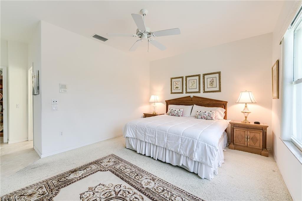 9156 Spring Run Boulevard Estero, FL 34135 - Photo 21 of 34 a bedroom with a bed and a ceiling fan