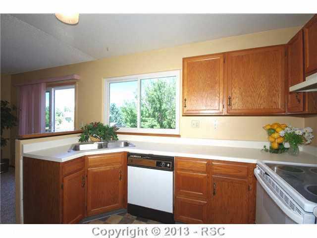 6630 Turkey Tracks Road Colorado Springs, CO 80922 - Photo 7 of 25 Counter space with stainless steel sink centered to face dining area or window.