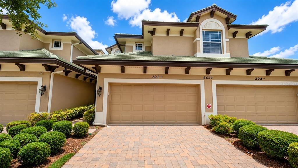 6552 Moorings Point Circle, Unit 102 Lakewood Ranch, FL 34202 - Photo 1 of 57 a front view of a house with garden