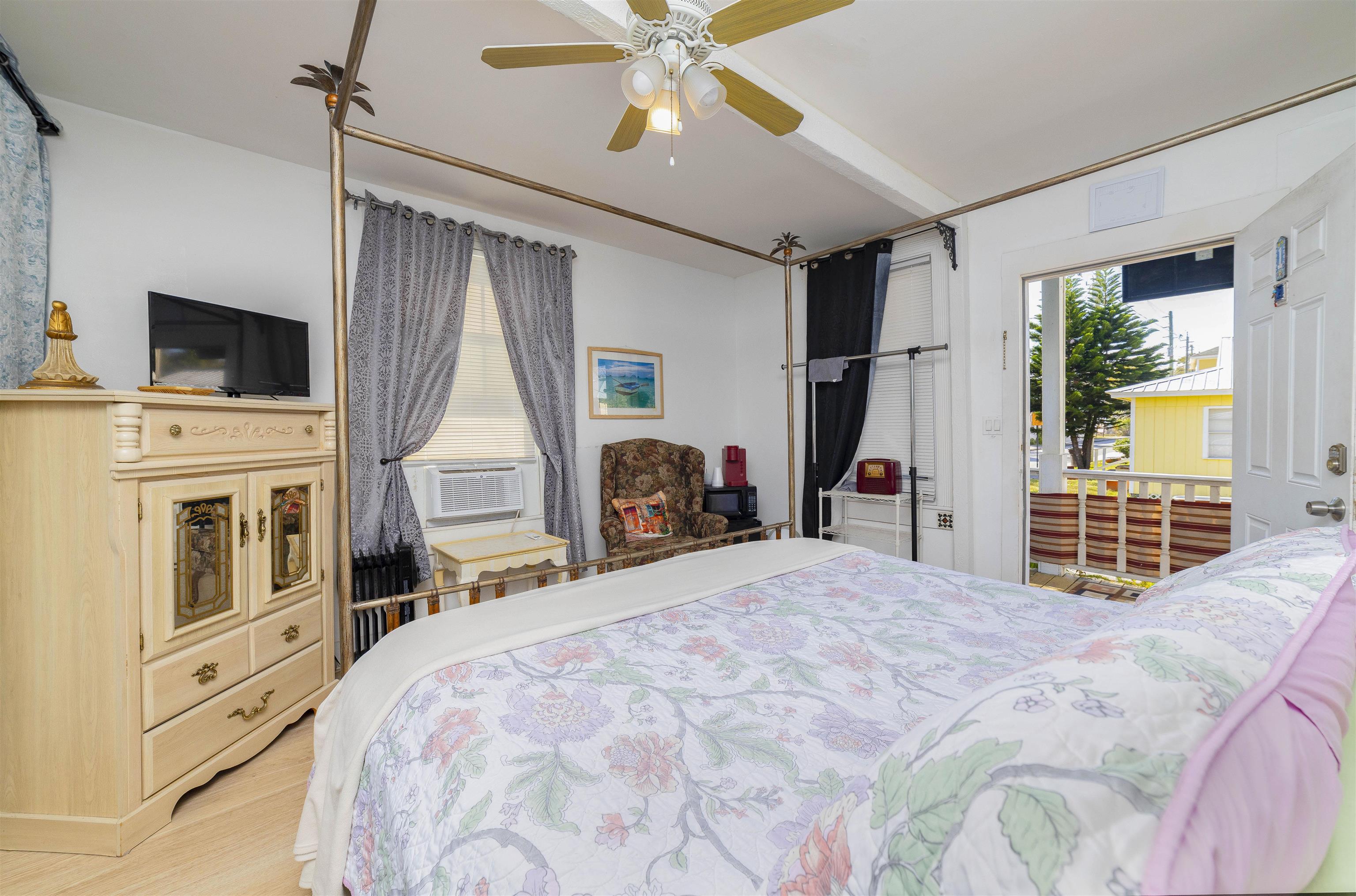 77 Oneida Street St. Augustine, FL 32084 - Photo 7 of 26 a bedroom with a bed a flat screen tv and a fireplace