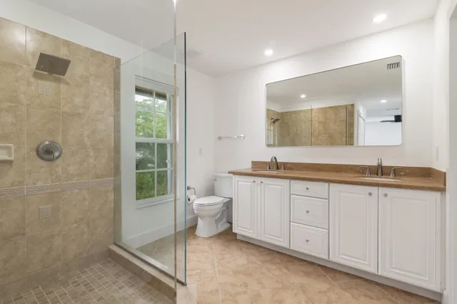 a bathroom with a granite countertop sink a toilet and a mirror