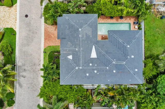 a sign of golf club on a wall under a tree