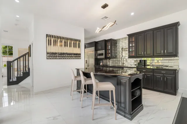 a kitchen with stainless steel appliances granite countertop a sink a stove a refrigerator and cabinets