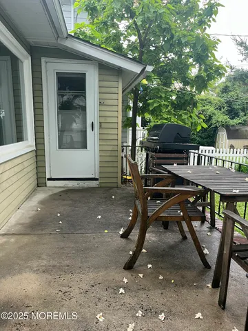 a view of a patio with table and chairs with wooden floor and fence