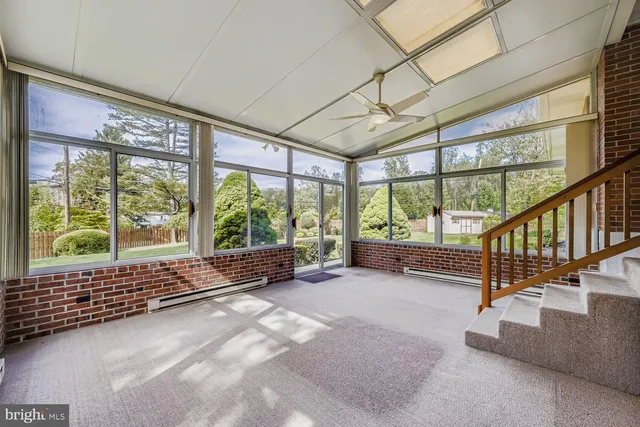 a view of an empty room with wooden floor and iron stairs