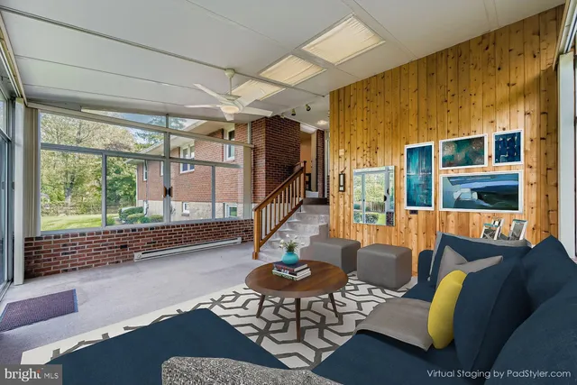 a living room with furniture and a floor to ceiling window