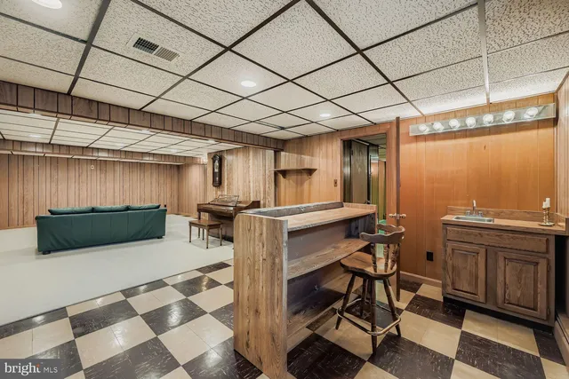 a kitchen with a sink a counter and chairs