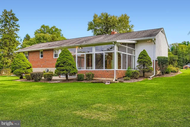 a view of a house with a yard and potted plants