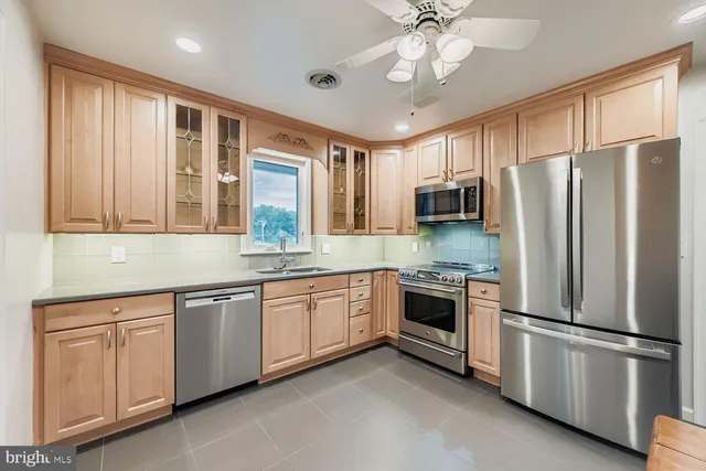 a kitchen with granite countertop stainless steel appliances a sink cabinets and a window