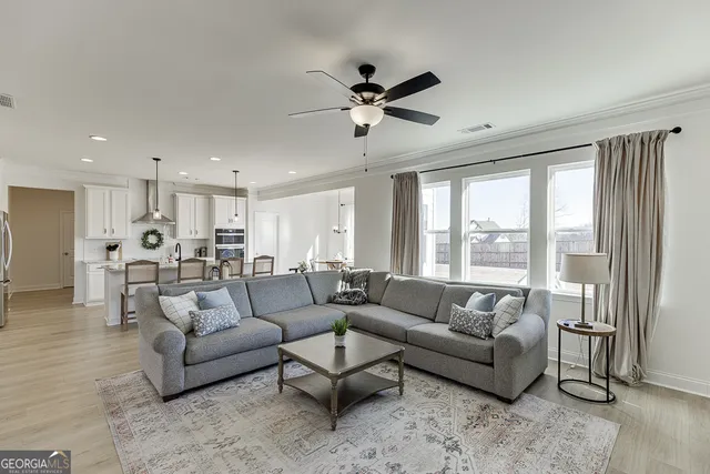 a living room with furniture and a view of kitchen