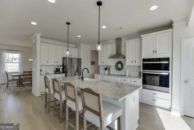 a large kitchen with kitchen island a large island a sink stainless steel appliances and cabinets
