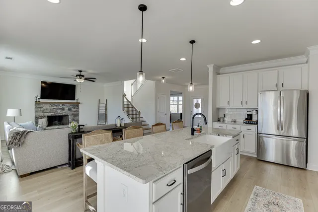a kitchen with center island a sink appliances and wooden floor