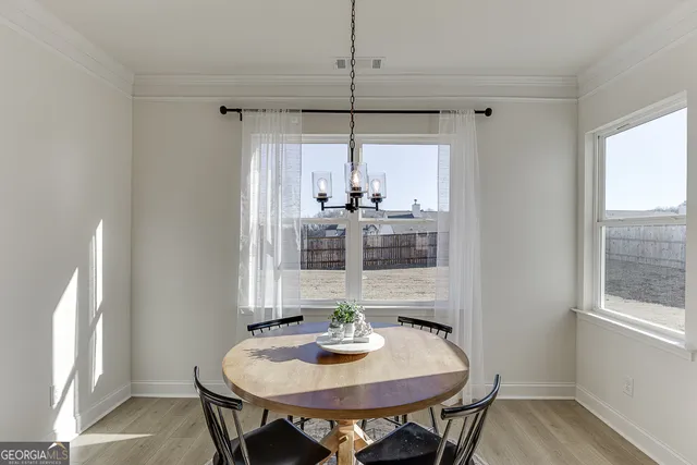 a kitchen with stainless steel appliances kitchen island granite countertop a dining table chairs and a refrigerator